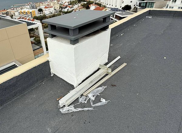The image depicts a messy rooftop area with leftover materials from solar panel installation.