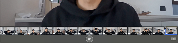 A man wearing glasses and a black shirt speaking in front of a microphone in a recording studio.