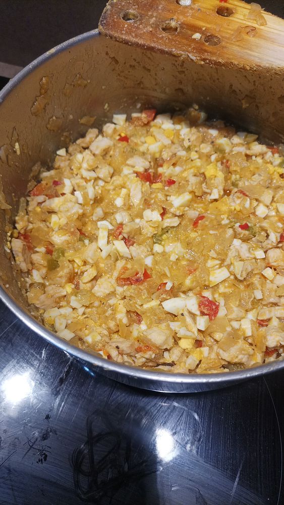 A pot filled with a mixture of diced chicken, vegetables, and hard-boiled eggs.