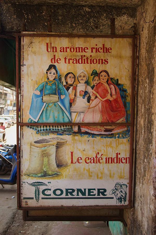 A vintage advertisement for Indian coffee featuring traditional characters.