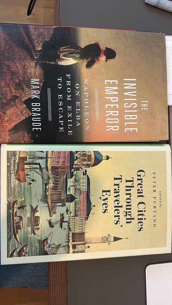 The image features two book covers placed on a table.