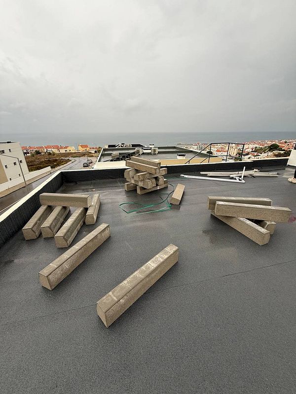 The image depicts a rooftop with several concrete blocks and no solar panels installed.