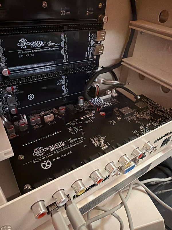 The image features a close-up view of a retro display's internal components, including circuit boards and connection ports.