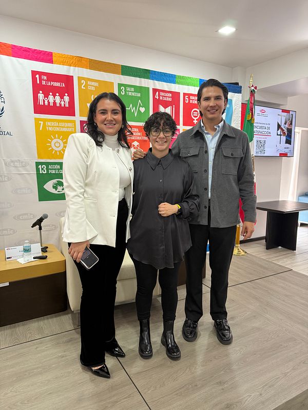 Three individuals pose together in a professional setting during an annual meeting debrief.