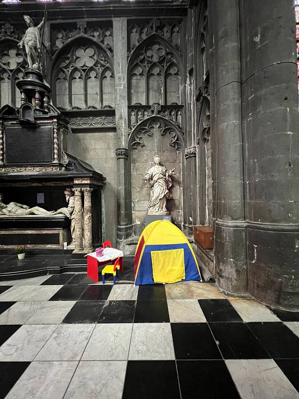A colorful children's tent and small table set up in a historic church interior.