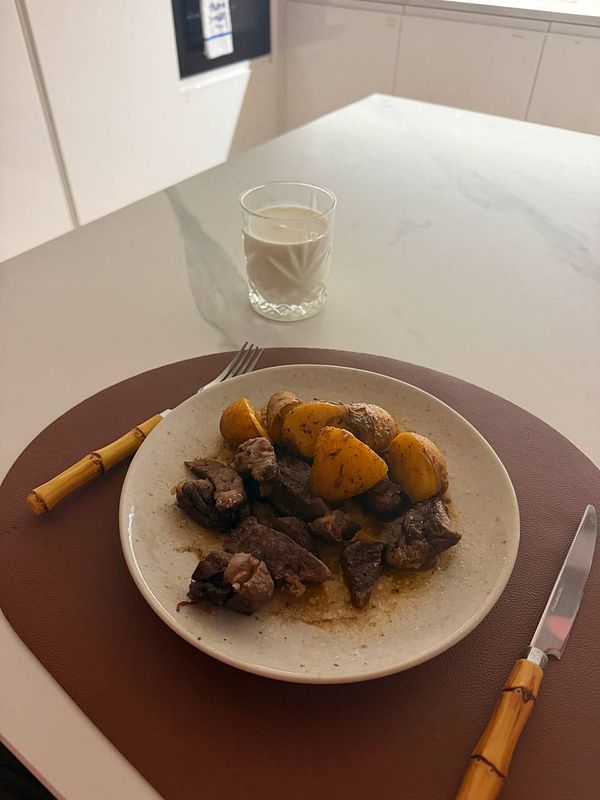 A late night snack plate with fried foods and a drink on a wooden table.