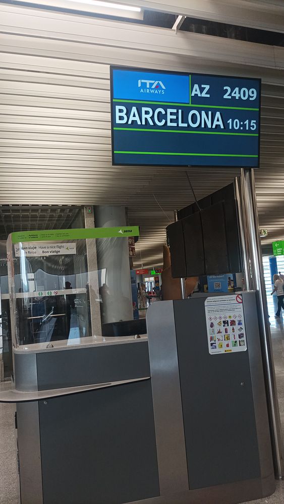 An airport departure board displaying a flight to Barcelona.