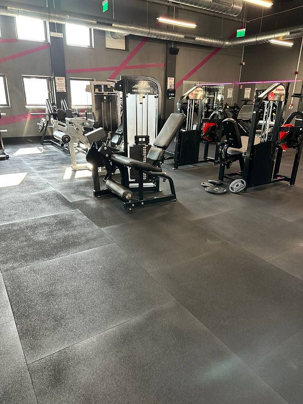 A well-equipped gym space featuring various exercise machines and a clean, modern design.