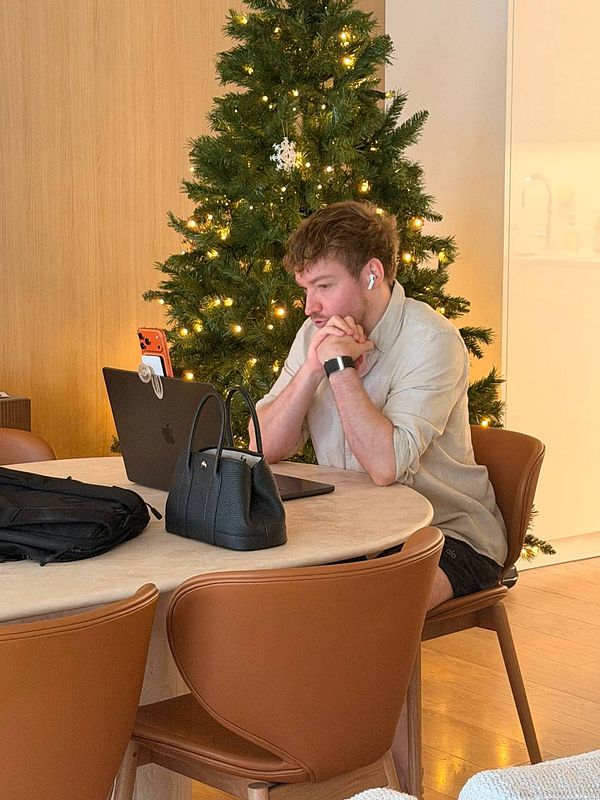 Photo of a meeting room setup with a notebook, pen, skull, and a circular object on a wooden table.