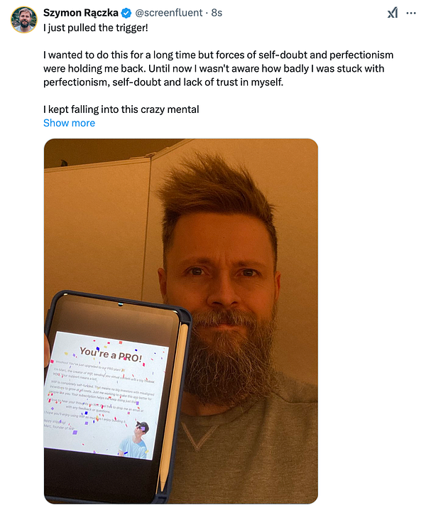 A man with a beard holds a device displaying a congratulatory message about a Pro membership.