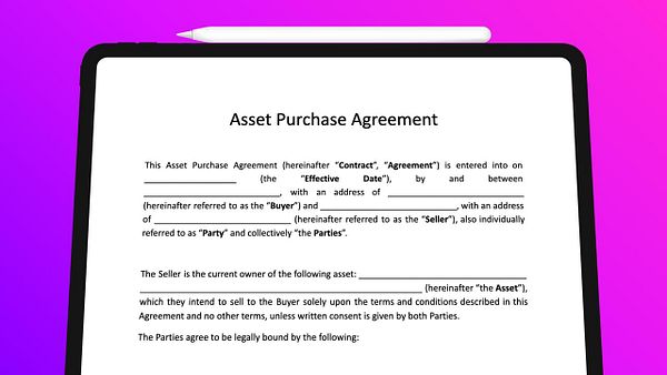 A formal printed document titled "Asset Purchase Agreement" placed on a wooden surface with a pen beside it.
