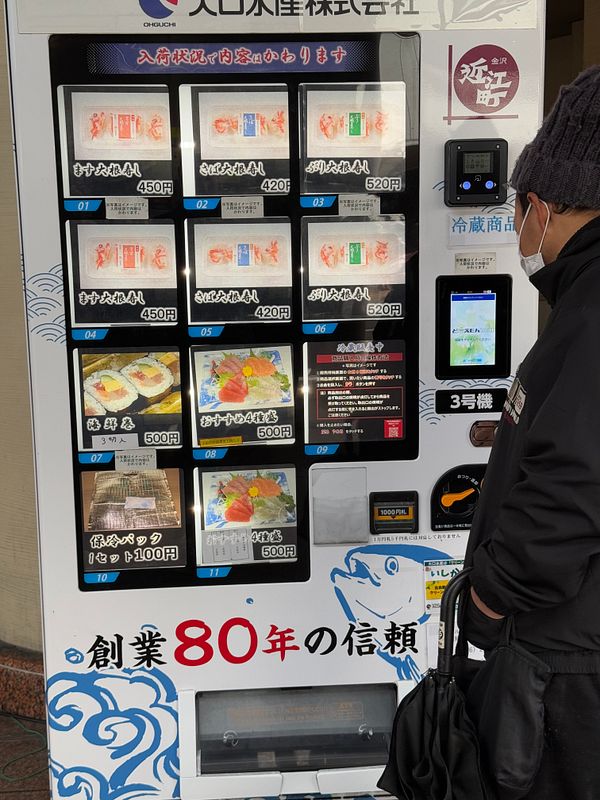 A person is standing in front of a vending machine that dispenses sushi.