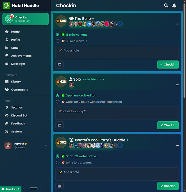 Two women are wearing colorful, traditional clothing and floral headpieces, standing in front of a scenic waterfront.