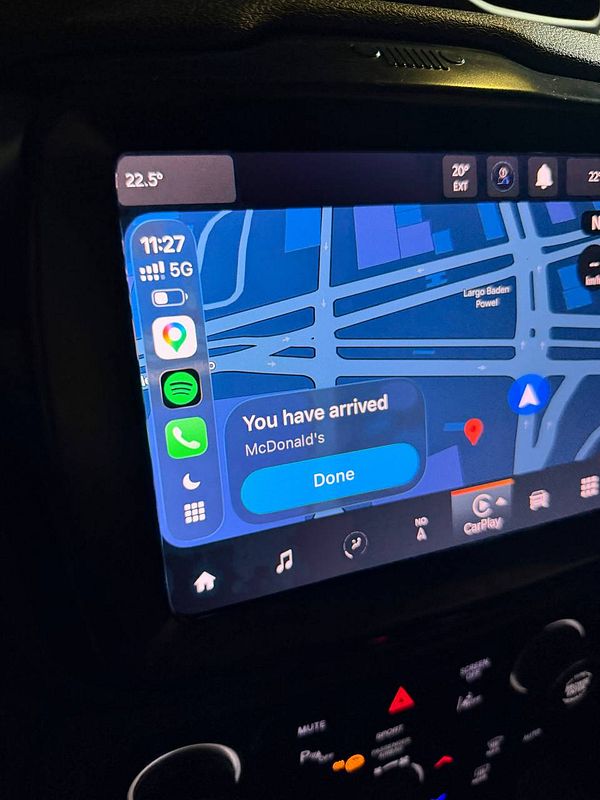 Photograph of a McDonald's McDrive pickup window with a car and menu board.