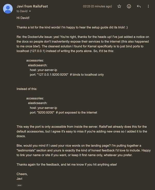 Close-up shot of a smiling man with neatly styled hair and a beard, wearing a black shirt against a vibrant pink background.