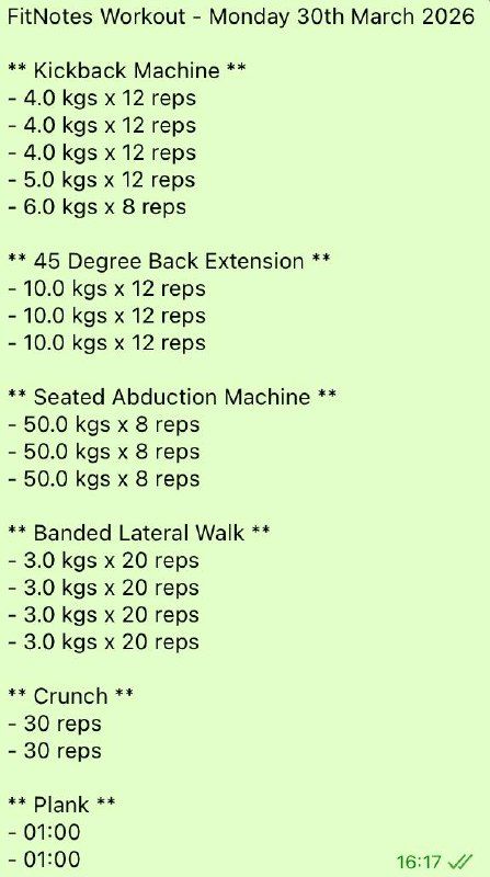 A muscular man with tribal tattoos performs a deadlift exercise lifting a weighted barbell in a gym.