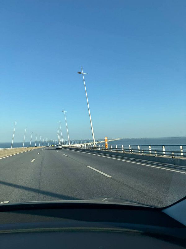 A scenic view of a road leading towards a bridge over water in Portugal.