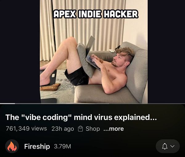 A man is lounging on a couch, working on a laptop while partially reclined.