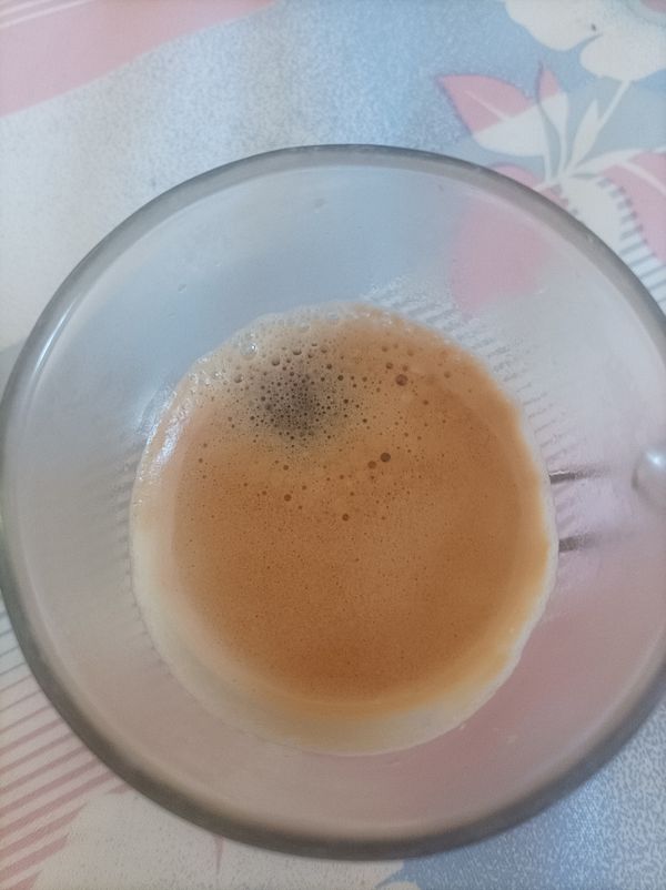 A close-up view of a glass containing a freshly brewed cup of coffee.