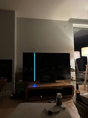 A broken LG 65" TV is displayed in a dimly lit living room.