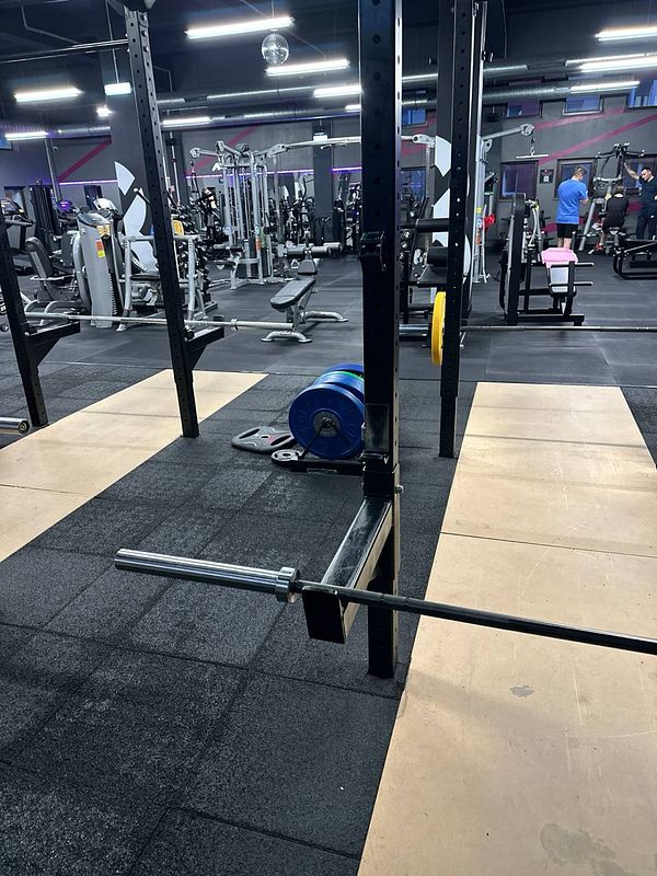 A gym setting featuring weightlifting equipment and various workout stations.