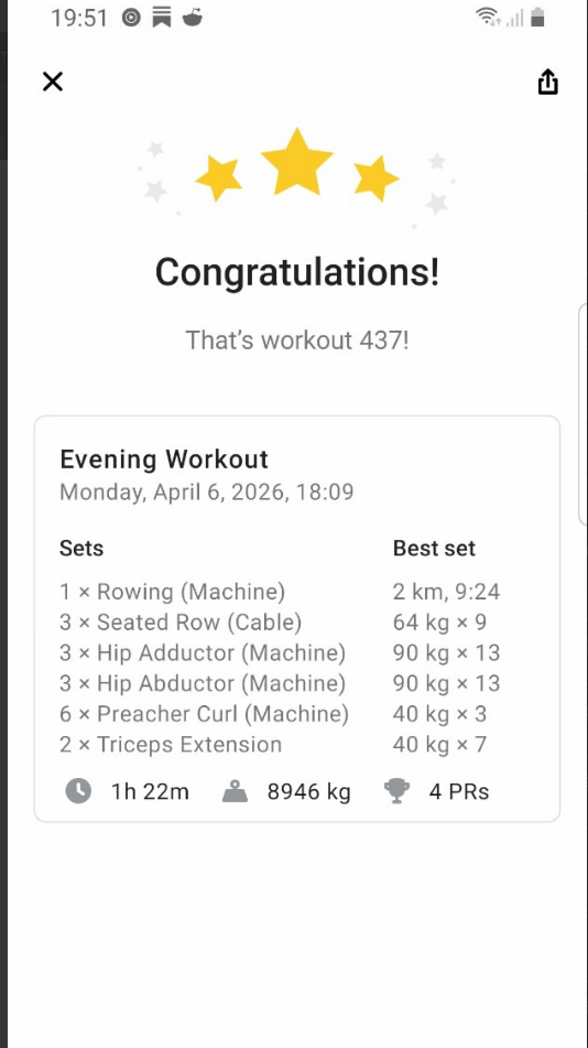A gym scene showing a man lifting dumbbells in front of a large mirror with workout equipment in the background.