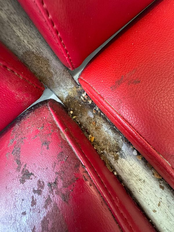 The image captures a close-up view of dirty and worn seating at Lisbon Airport.