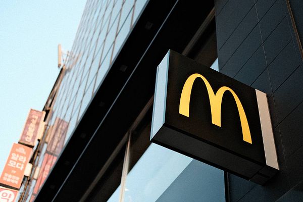 A vibrant street market scene in a small town with a blue sky and various shops.