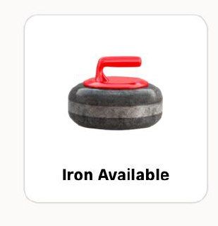 An electric travel iron with a cord and adjustable temperature dial on a wooden surface.