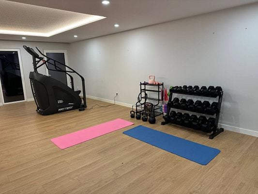 A partially completed home gym featuring exercise equipment and workout mats.