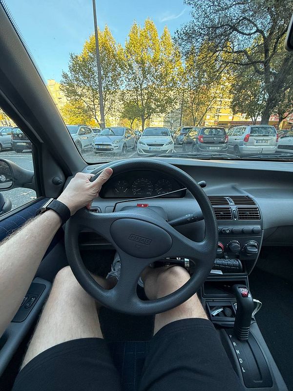 A driver's perspective from inside a parked car, showing the steering wheel and dashboard.