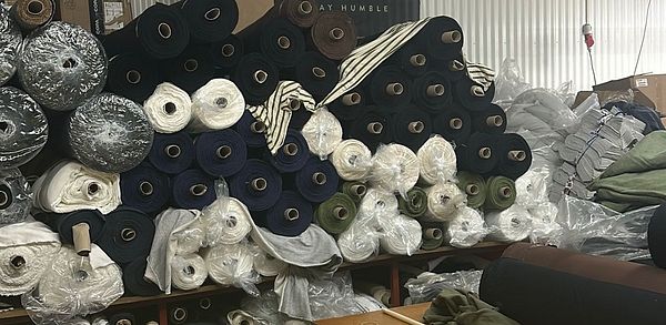 A collection of fabric rolls stacked in a production area.