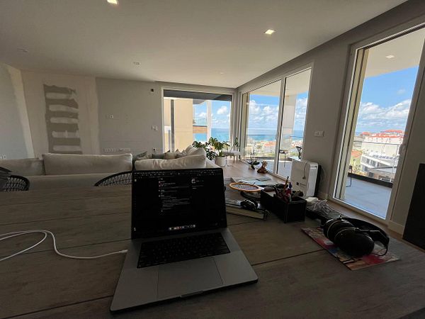 A modern workspace with a laptop and a scenic view of the ocean.