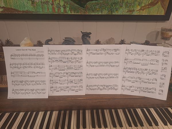 Sheet music for Linkin Park's 'Leave Out All the Rest' is displayed on a piano.