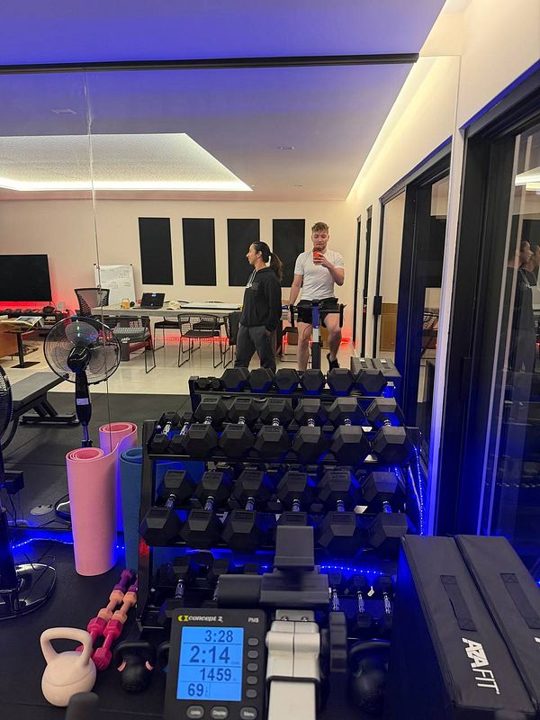 A modern, wooden-legged chair with a gray cushioned seat and backrest, set against a plain white background.