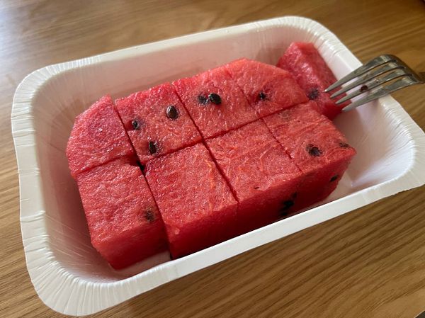 A container filled with neatly cut watermelon pieces.