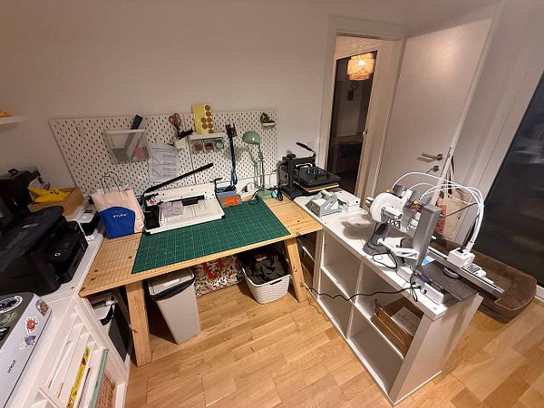 A workspace setup featuring various machines and tools for crafting or design projects.
