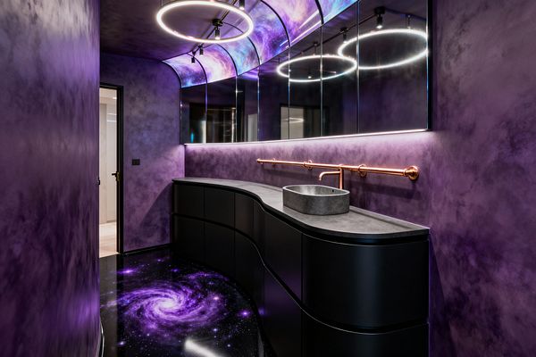 A narrow laundry room features textured purple walls, a high-gloss black floor printed with a violet galaxy, and curved matte-black cabinetry topped by a charcoal concrete counter. A round concrete vessel sink sits beneath mirrored cabinets with an LED strip, while a linear copper pipe faucet and rail stretch across the wall; above, ring pendants, track spots, and a curved ceiling panel painted with nebula imagery create a bright, futuristic glow.