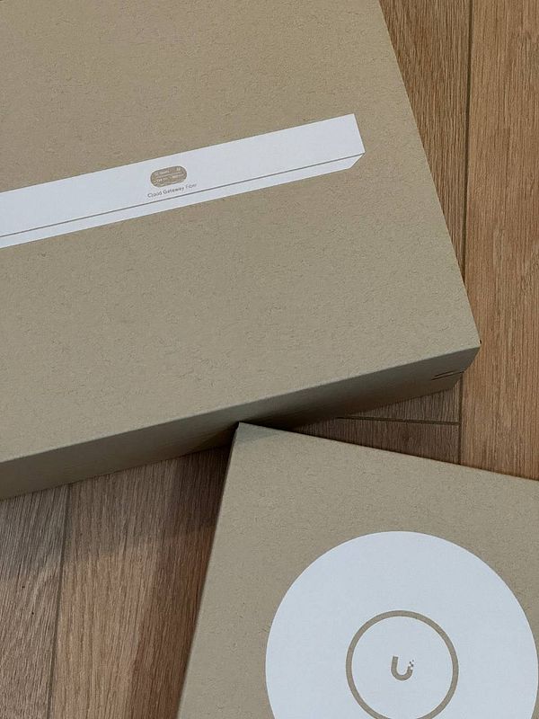 Photo of a home networking setup showing TP-Link devices including a router, a switch, and a range extender mounted on a wooden wall.