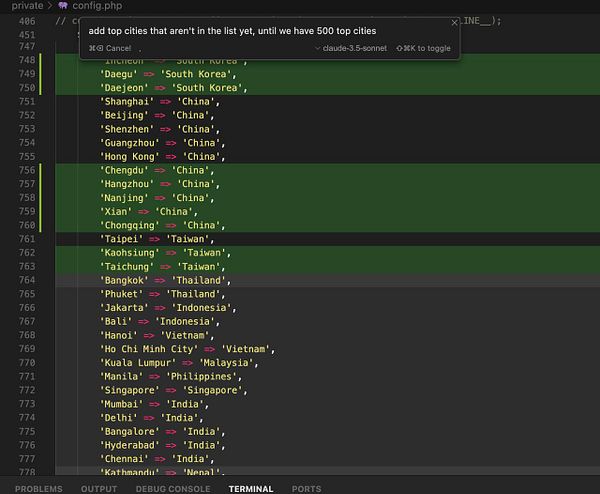The image displays a code snippet from a PHP configuration file listing cities and their corresponding countries.