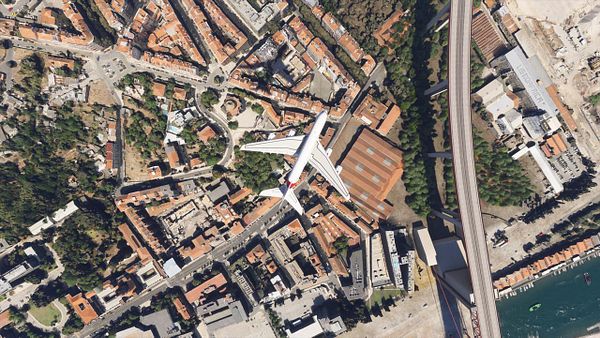 An aerial view of an A380 aircraft flying over a densely populated area in Lisbon.