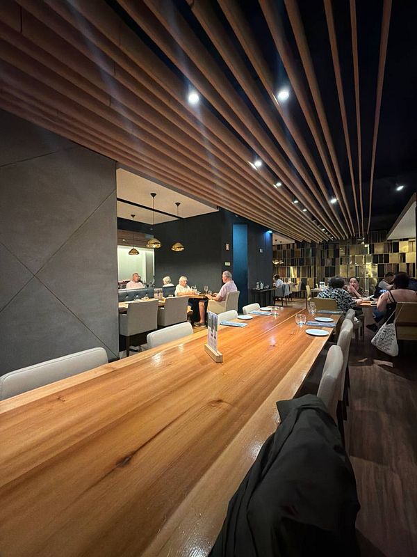 Interior of Butchers classic steak restaurant in Lisbon showing a rustic dining area with wooden furniture and a bar counter.