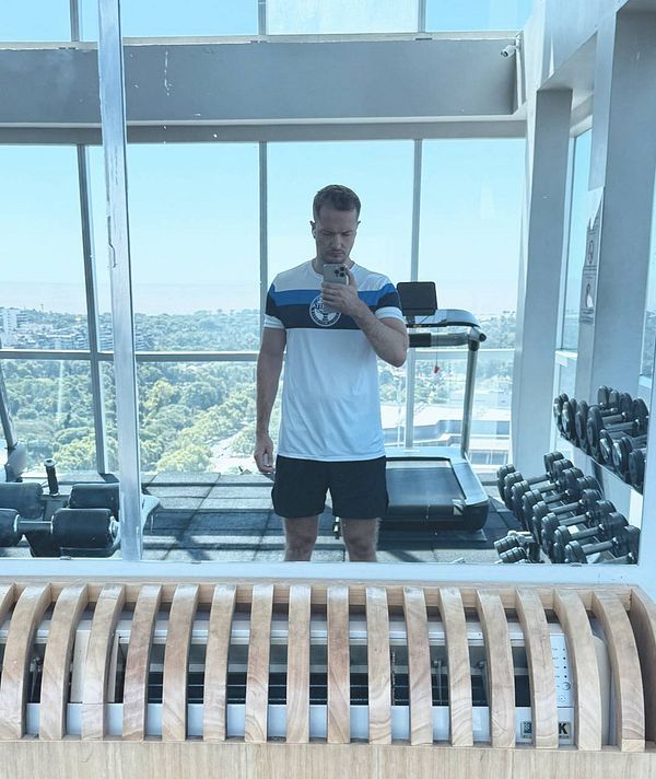 A person is taking a mirror selfie in a gym setting.