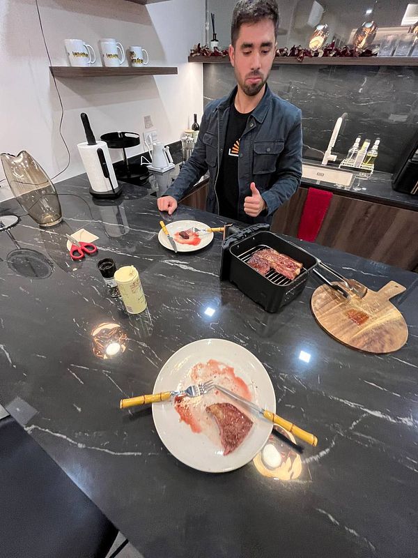 A man stands in a modern kitchen, looking disappointed while preparing a meal.