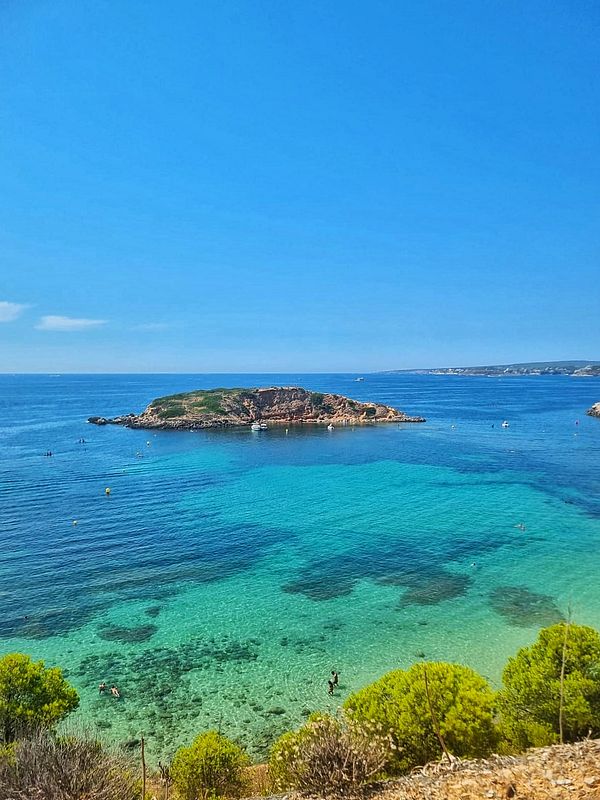 A picturesque coastal scene featuring clear turquoise waters and a small island.