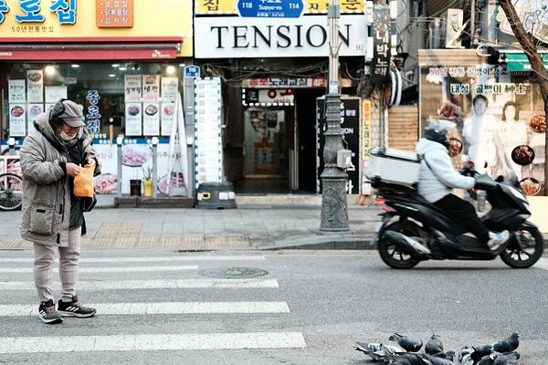A sunrise landscape photograph featuring silhouetted trees and a bridge over water with a reflection beneath an orange-pink sky.