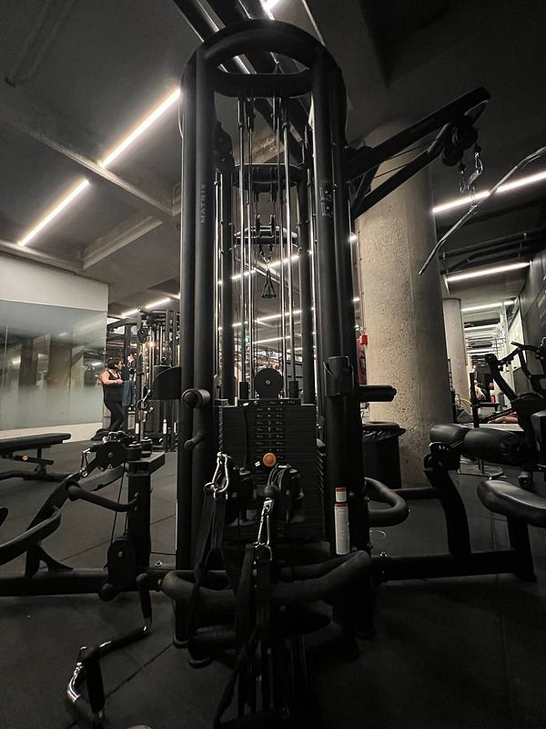 A gym interior featuring a cable machine and workout equipment.