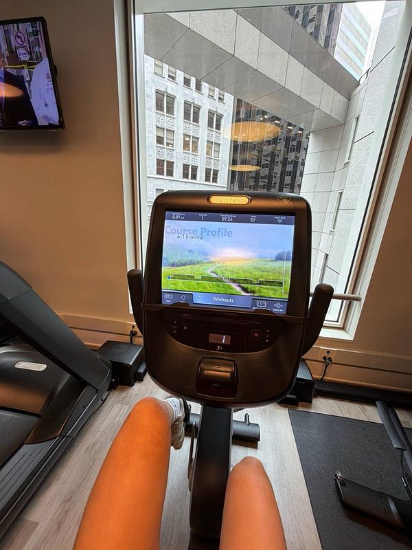 A woman exercising on an elliptical machine in a gym setting.