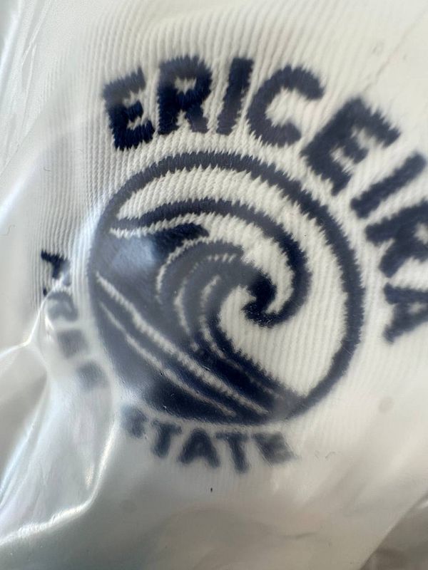 The image features a close-up of a logo on a hat.