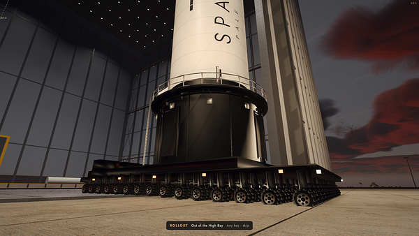 Close-up view of a large rocket base with tracked wheels, situated inside a spacious launch bay during sunset.